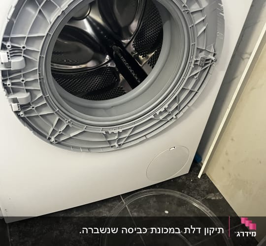 מכונת כביסה פתוחה עם קערה על הרצפה